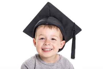 Adorable four years old child boy wearing a mortar board.