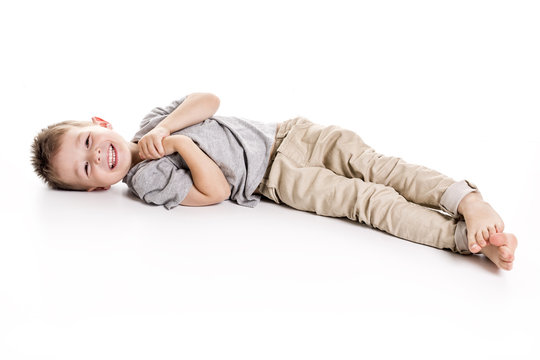 Four years boy lying on floor isolated on white