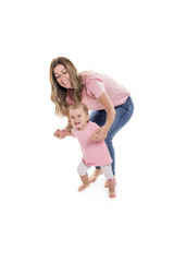 baby girl learning to walk with the help of her mother