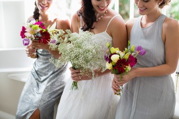 Bride and bridesmaids standing with bouquet