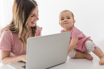Mom and baby with laptop computer working from home