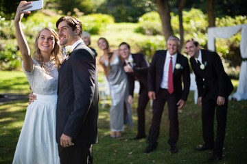 Couple taking selfie with guests during wedding