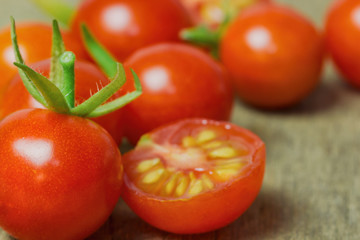 Fresh cherry tomato on rustic wood table. Close up lovely cherry tomato for background or wallpaper. Prepare fresh cut cherry tomato for home cooking look so delicious. Macro concept with copy space.