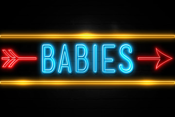 Naklejka na ściany i meble Babies - fluorescent Neon Sign on brickwall Front view
