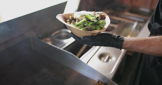 Food Truck owner plating up a dish