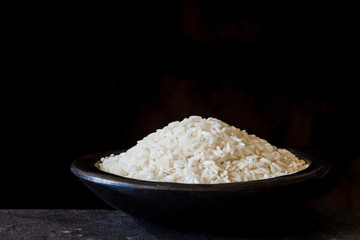 Raw rice grains in a traditional black clay dish
