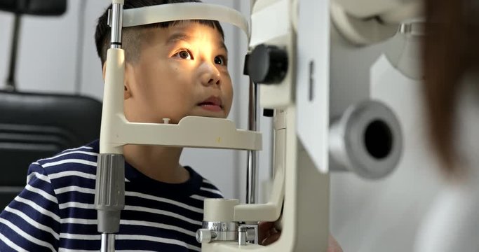 Little boy doing eye test at the optical store