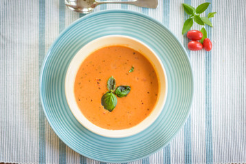 Overhead food shot of bowl of warm tomato basil soup