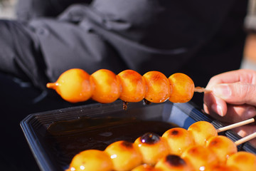 Japanese Kushi Dango with sweet shoyu sauce on top on the black dish in sunny day in Kyoto, Japan  backgroundbeautifulbeautyblackburnclosecloseupcolorfulcuisineculturedangodaydeliciousdesigndessertdis