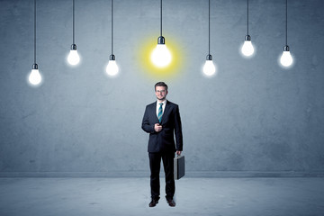 Obraz premium Businessman standing uninspired with bulbs above