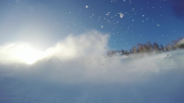 Extreme skier spraying snow in slow motion in sunny mountain with bokeh and lens flare effects. 1920x1080
