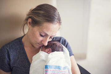 Mother holding her newborn premature baby in the hospital