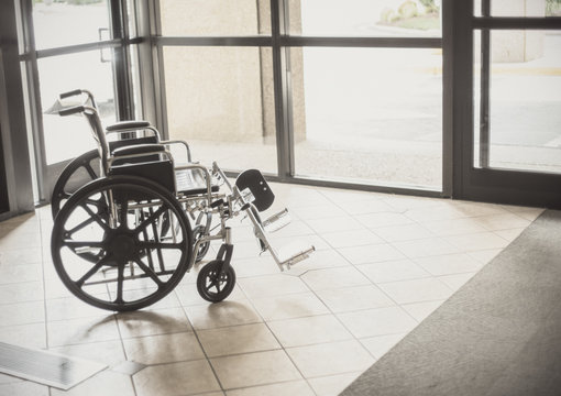 Solitary wheelchair resting in the lobby of a hospital. Abstract healthcare and disability image