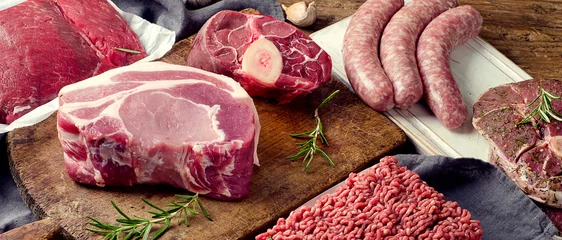 Zelfklevend behang Vlees Verschillende soorten vers rauw vlees op donkere houten ondergrond.