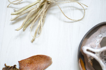 Decorative pottery. Ceramics coffee cup on the white wooden bacground with dried flowers and cinnamon