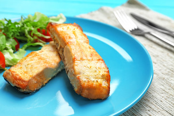 Plate with salad and delicious slices of salmon, closeup