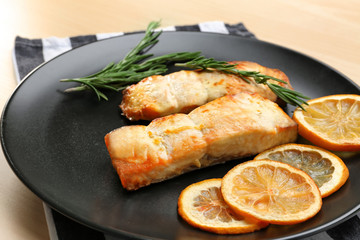 Plate with slices of lemon and salmon on light table