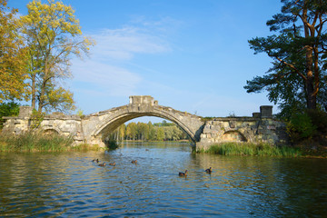 Humpbacked bridge on the White Lake on a sunny September day. Gatchina, Russia