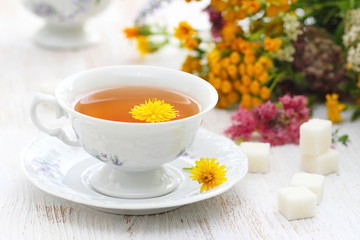 Cup of herbal tea and flowers