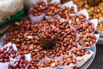 Stirred fire Peanuts topping with salt in paper cone at street local market in Darjeeling. India.