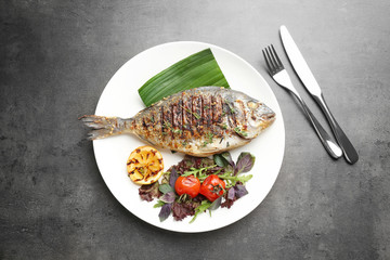 Plate with delicious fried fish on table