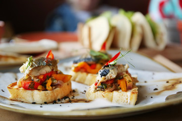 Delicious molletes with fillet of fish and vegetables on plate