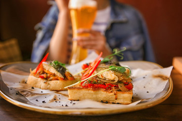 Plate with delicious molletes and woman on background