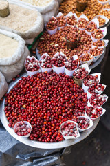 Red Berries and Stirred fire Peanuts topping with salt in paper cone at street local market in Darjeeling. India.