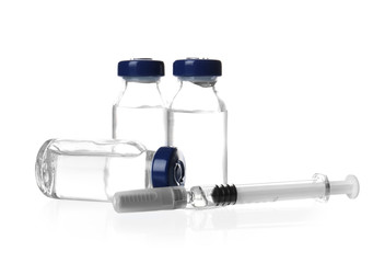 Ampules with vaccine and syringe on white background