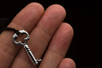 hand holding a small silver key