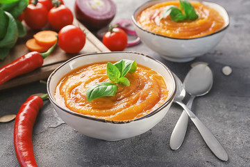 Bowls with delicious carrot soup on table