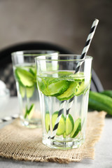 Delicious refreshing water with mint and cucumber in glasses on table