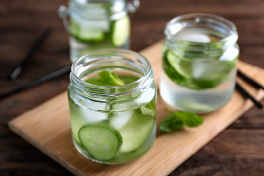 Delicious refreshing water with mint and cucumber in glass jar on table