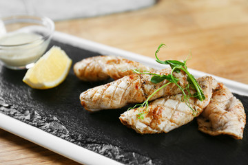 Slate plate with delicious squids on table