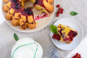 A large piece of cottage cheese cake with summer berries, jam  and a jug of milk on white background. The top view