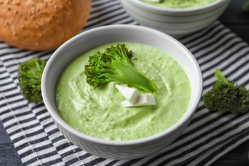 Bowl with delicious broccoli soup on table