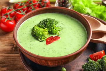 Bowl with delicious broccoli soup on table