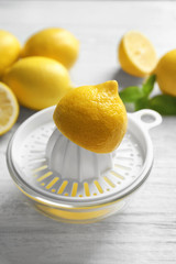 Half of lemon on plastic squeezer on table