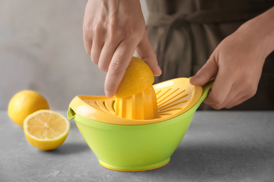 Man extracting lemon juice with plastic squeezer