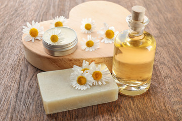 Composition with chamomile essential oil and soap on table
