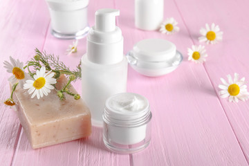 Fototapeta na wymiar Composition with cosmetic products and chamomile flowers on table