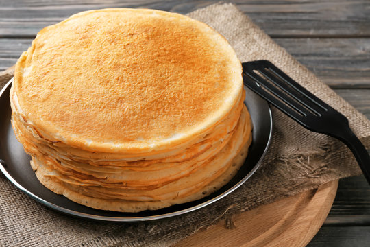 Stack of delicious thin pancakes on frying pan