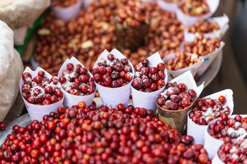 Red Berries topping with salt in paper cone at street local market in Darjeeling. India.