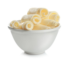 Bowl with delicious butter curls on white background