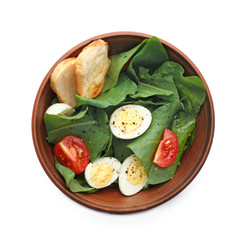 Salad with quail eggs and spinach in bowl isolated on white