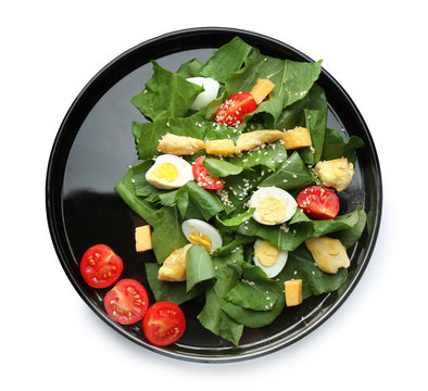 Plate of salad with quail eggs and spinach isolated on white