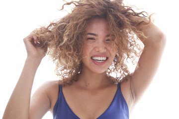 Portrait of a smiling and curly woman with freckles.