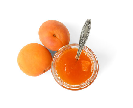 Apricot jam in jar with spoon and fresh fruit isolated on white