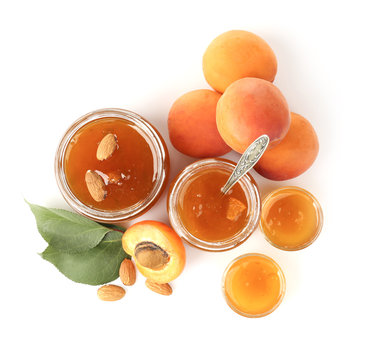 Apricot jam in jars and bowls with fresh fruit, isolated on white