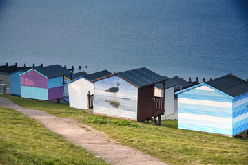 Blue sky and colorful beach huts along the coastline of Whitstable